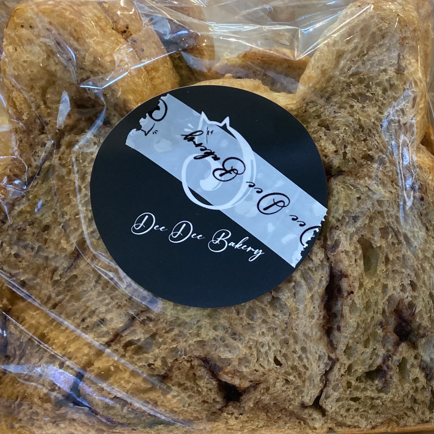 cat shaped bread with brown streaks in a clear plastic bag and a sticker "Dee Dee Bakery"