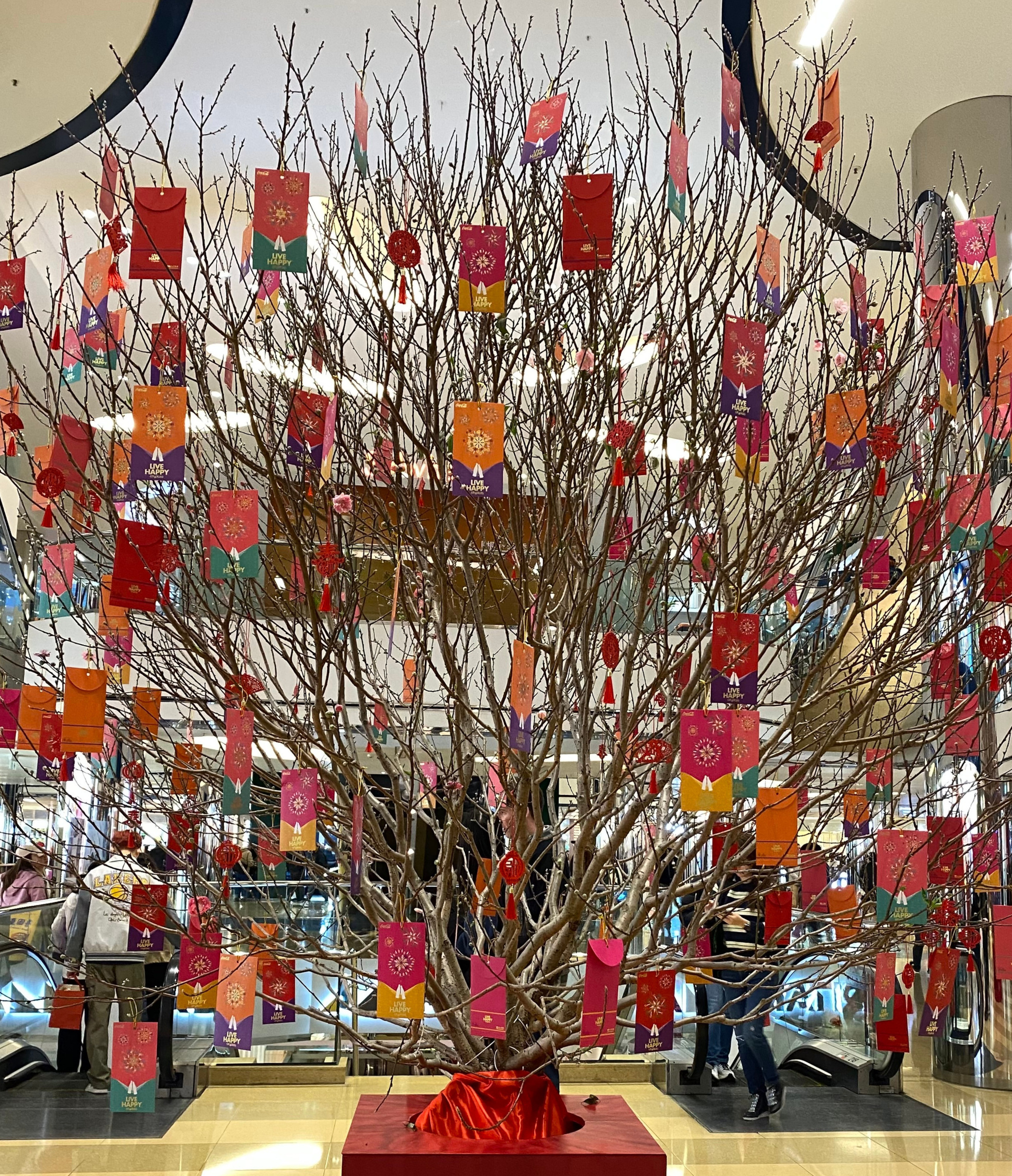 A tree inside a mall with red envelopes as leaves.